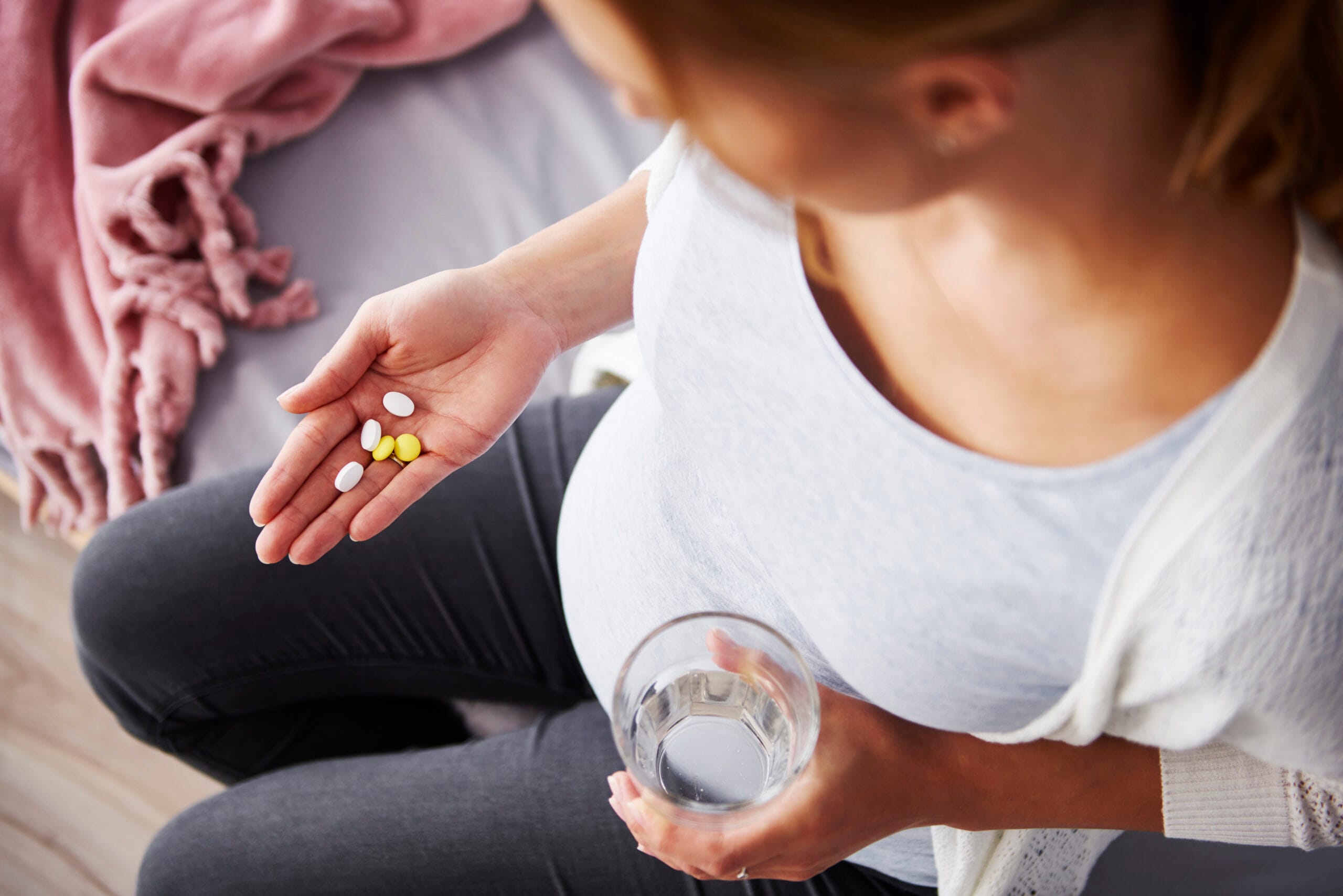 Young pregnant woman taking medicine FREEPIK